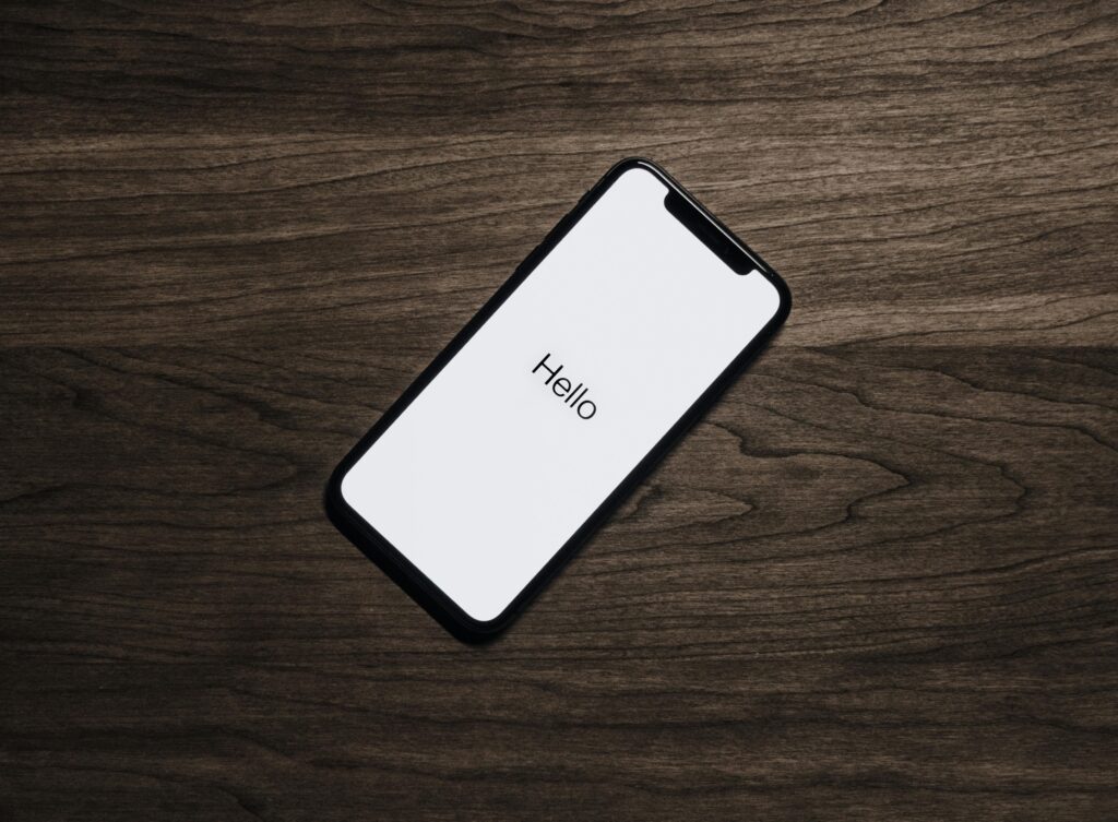 pexels-photo-699122-699122 A smartphone displaying 'Hello' on a wooden surface, showcasing modern technology.